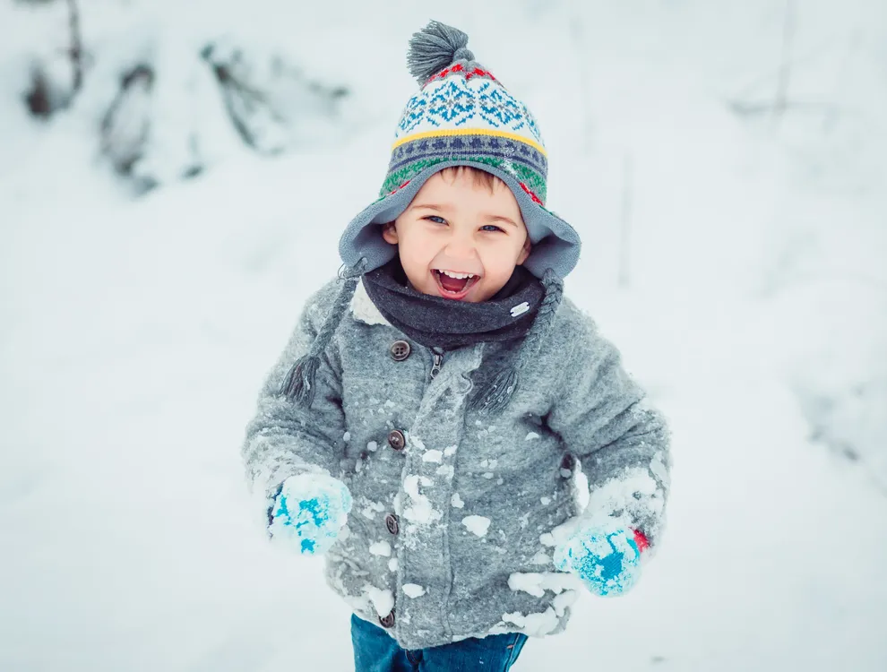 el-nino-pequeno-corriendo-lo-largo-de-la-nieve